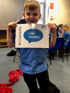 Boy holding an I'm Caring poster