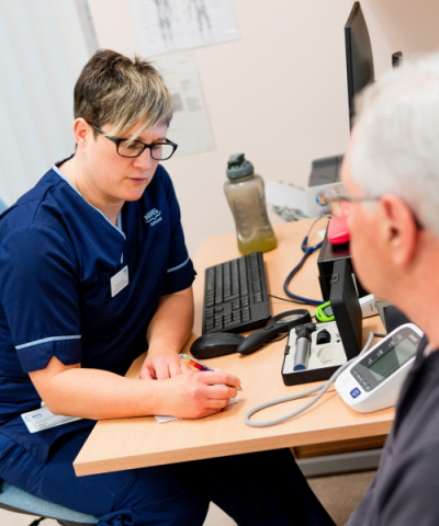 Male patient with a female nurse who is taking notes in a folder