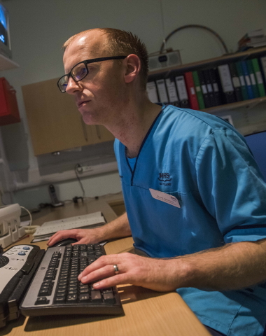 Male nurse looking a computer screen